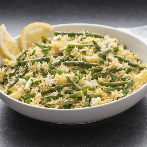 fluffy orzo and asparagus salad with lemons in shallow white bowl