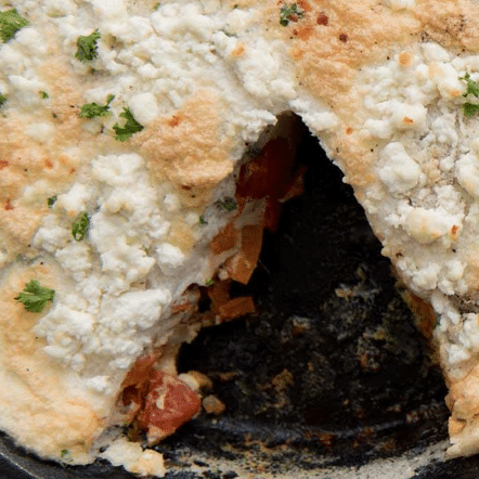 close up of goat cheese frittata with a slice taken out