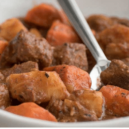 close up of white bowl of beef stew